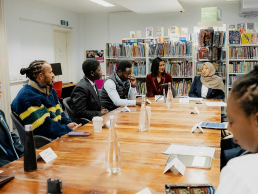 Yamina Bibi sharing the work of the Increasing Diversity in ITT project with Sir Lewis Hamilton and others at the roundtable